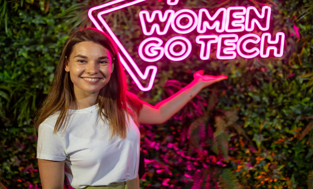 Woman standing in front of a logo "Women go tech". 