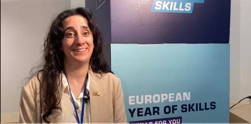 Woman standing in front of European Year of Skills signpost. 