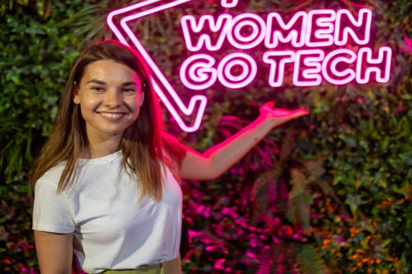 Woman standing in front of a logo "Women go tech". 